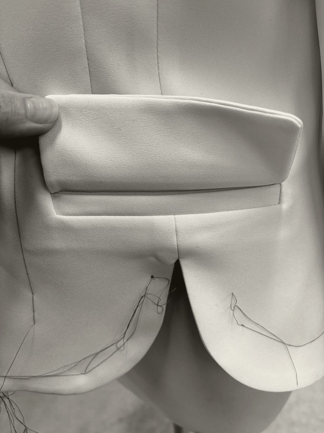 A finished wool blazer beside its paper pattern piece