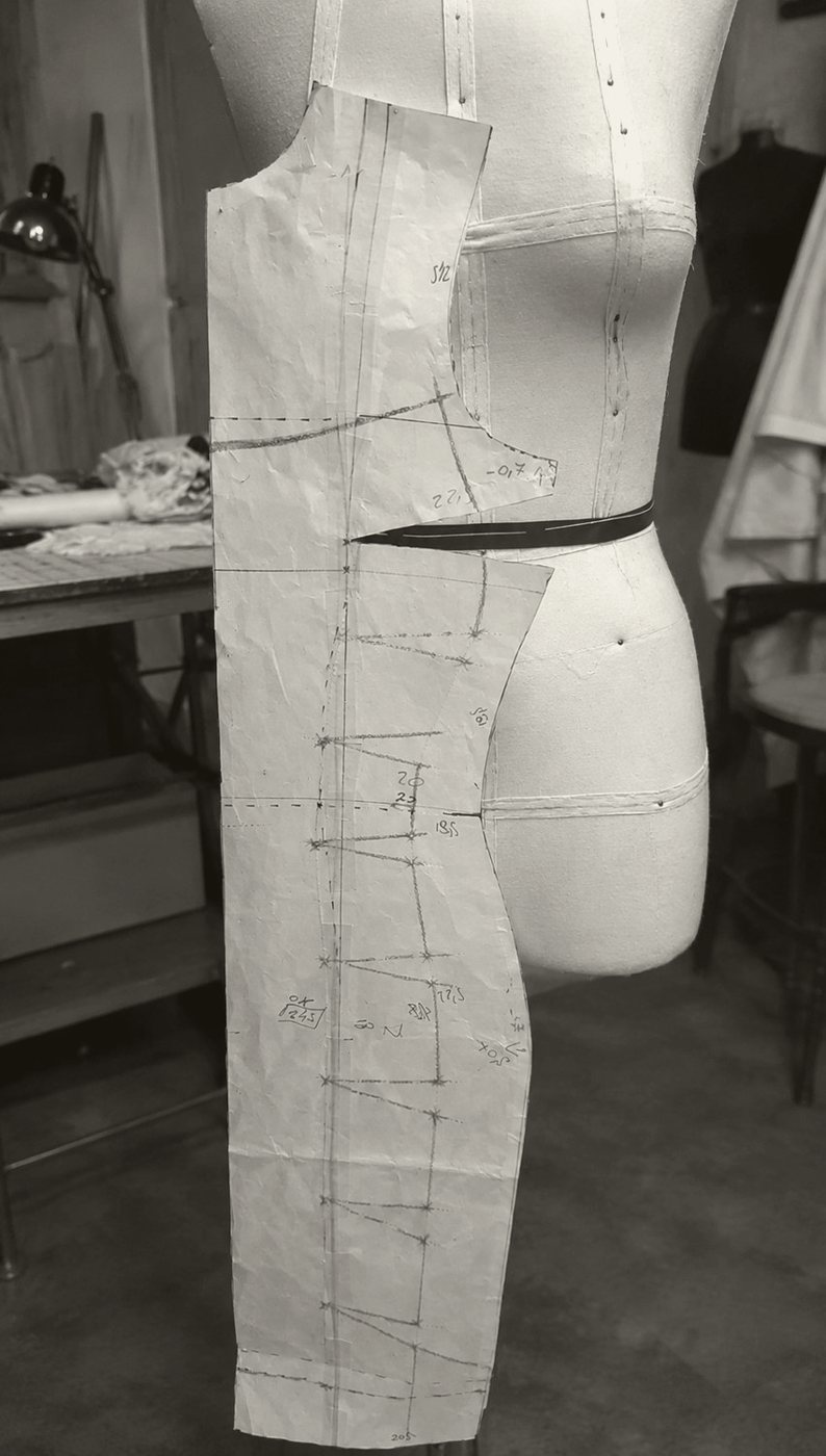 A paper dress pattern on the form, engineering the lace-up side seams