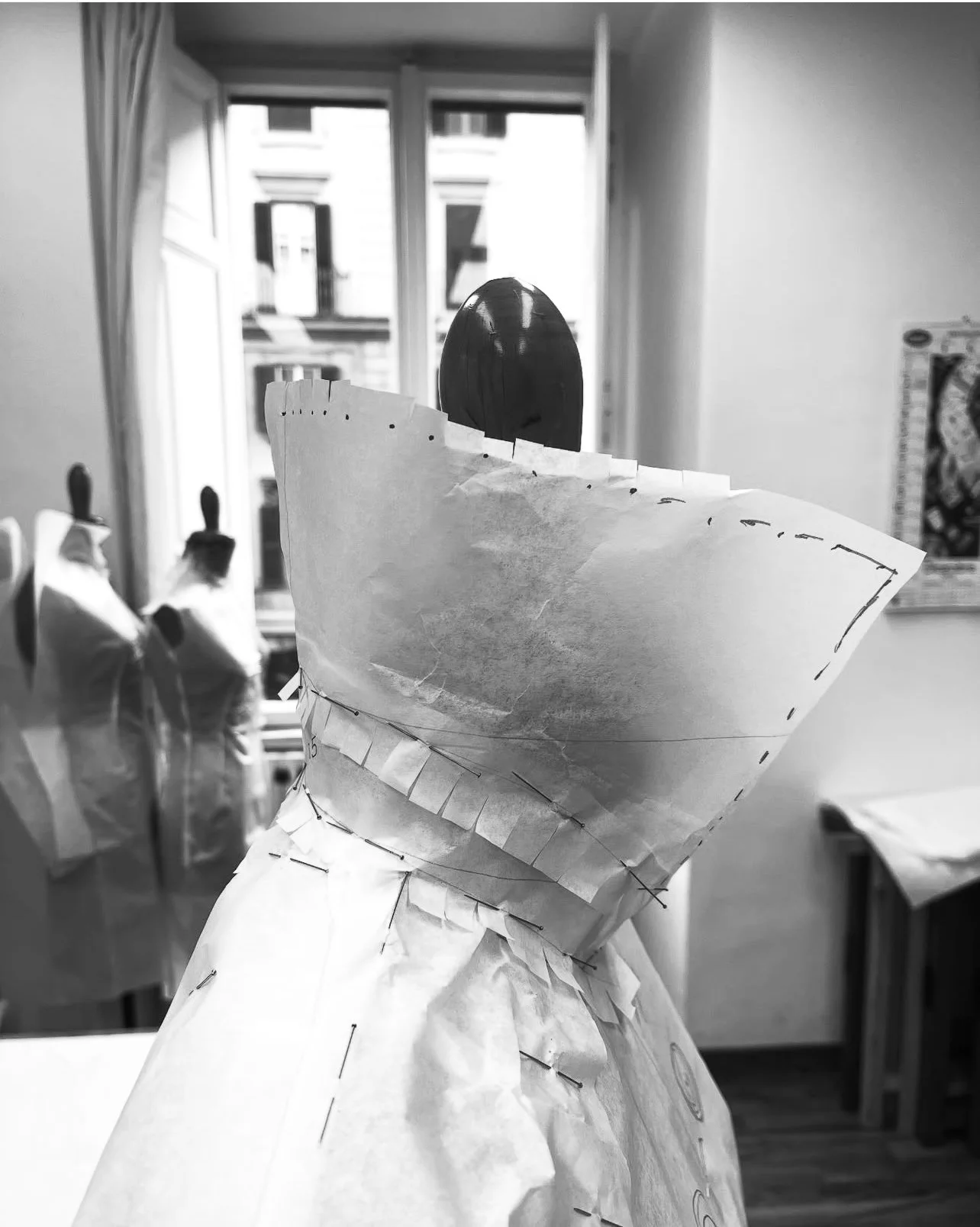 A paper toile draped on the mannequin