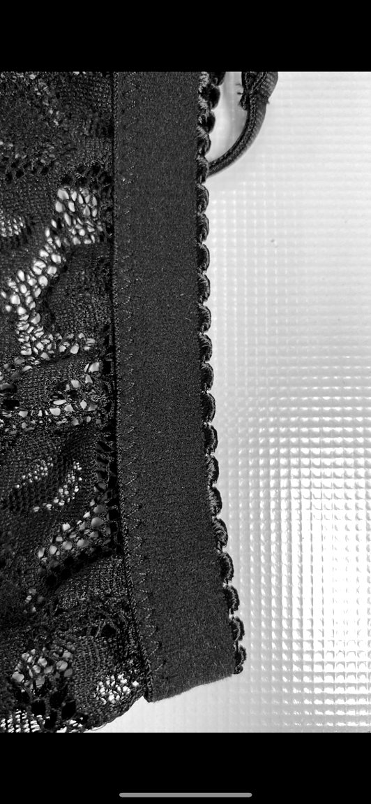A scalloped elastic trim applied to a lace panty with a zig-zag stitch, close
