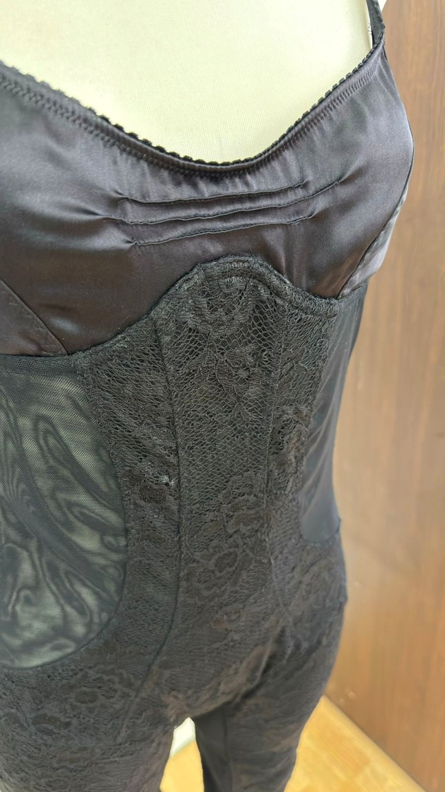 A silk and lace catsuit with mesh side panels, side view on the form