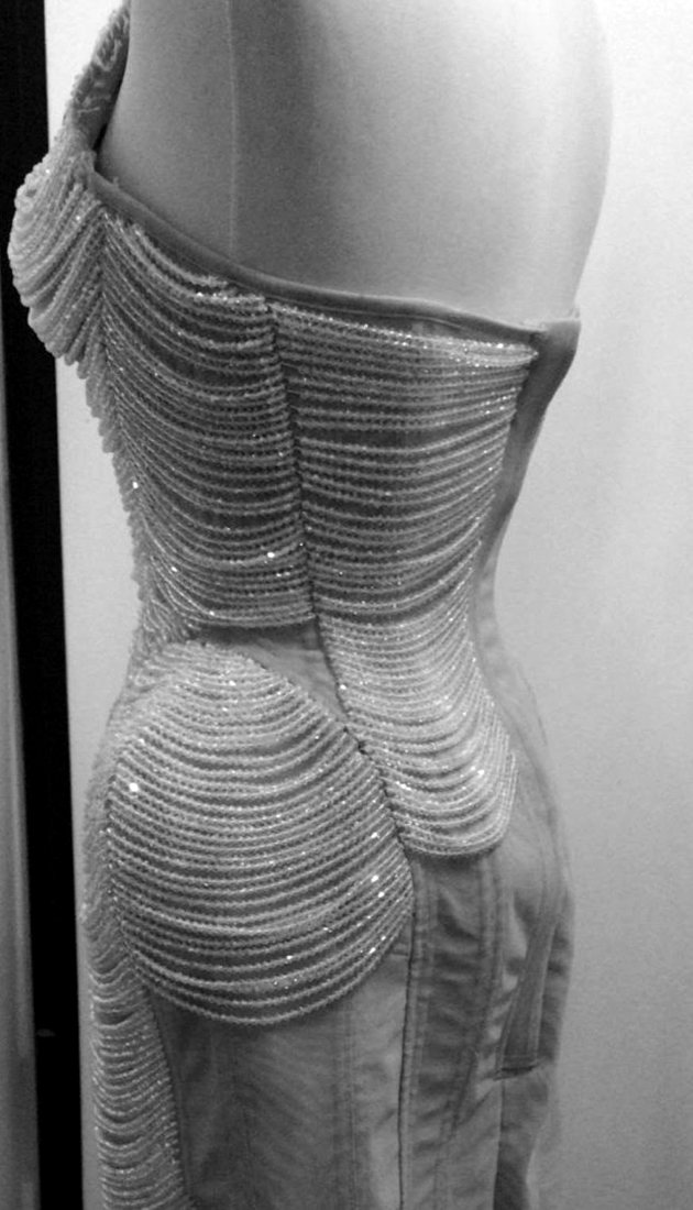 An embroidered eveningwear gown, side, on the form