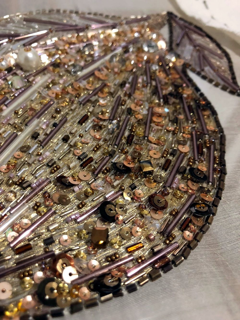 Dense gold bugle-bead and sequin fringe embroidery