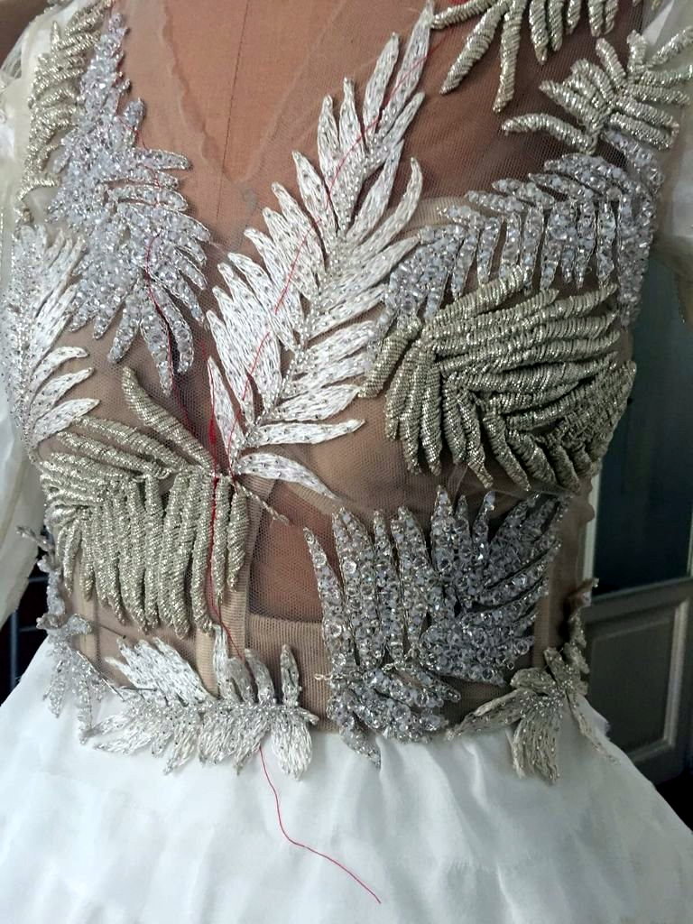Silver fern beadwork finished on a gown bodice